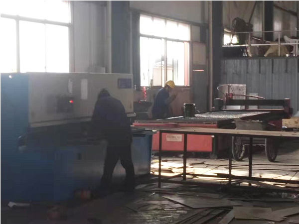 昊阳环保的工人正在用机器切割滤筒除尘器用钢材